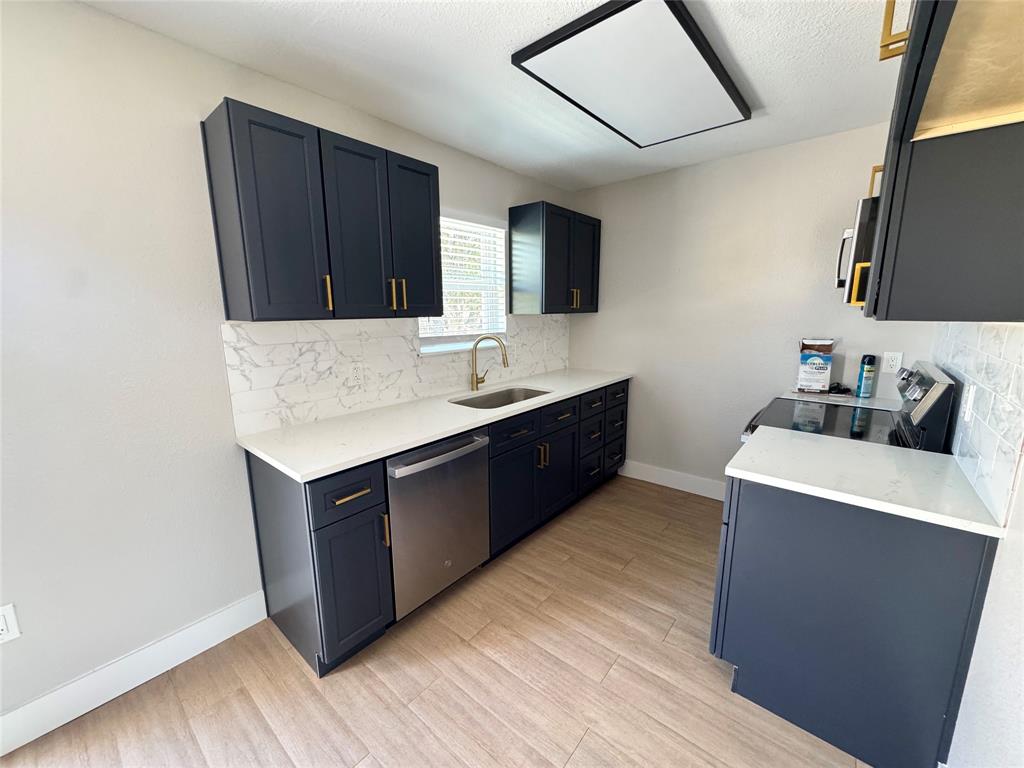 3824 Patman Street Lancaster, TX 75134 - Photo 7 of 24 a kitchen with stainless steel appliances granite countertop a sink and a refrigerator
