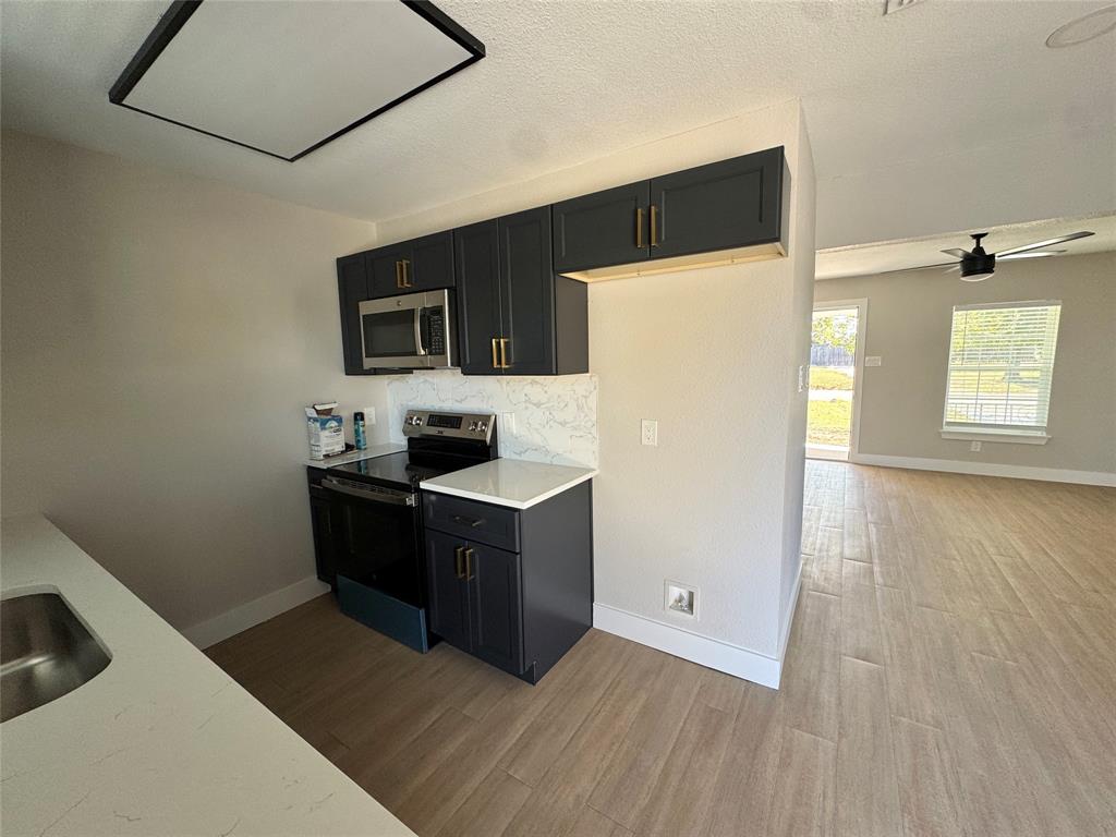 3824 Patman Street Lancaster, TX 75134 - Photo 9 of 24 a kitchen with a refrigerator and a stove top oven