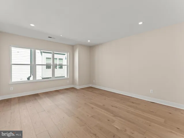 an empty room with wooden floor and bathroom