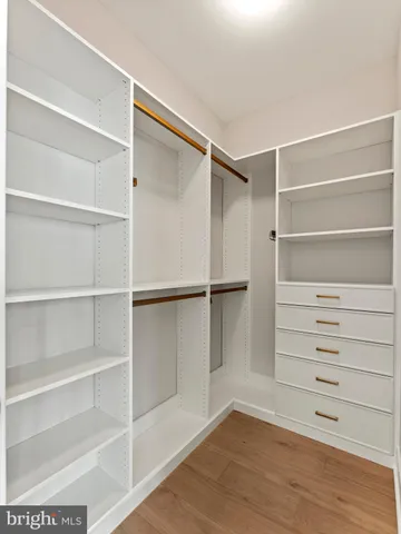 a view of walk in closet with empty racks