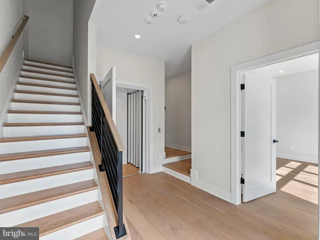 a view of a hallway with wooden floor and entryway