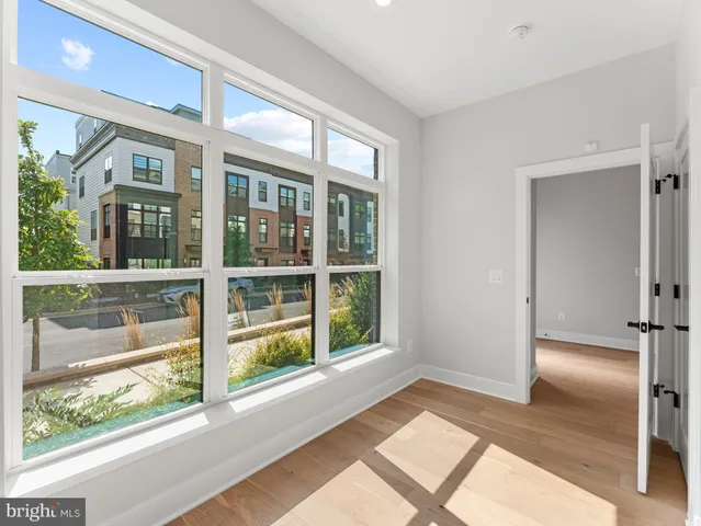 a view of a livingroom with wooden floor and a hallway