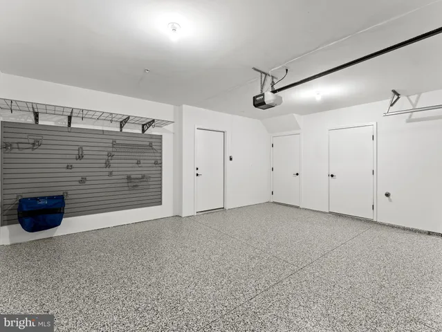 a view of an empty room with kitchen and a window