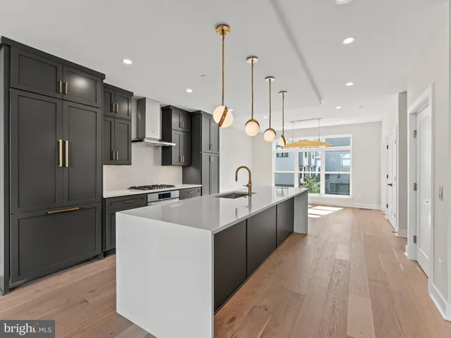 a kitchen with stainless steel appliances a sink stove and cabinets
