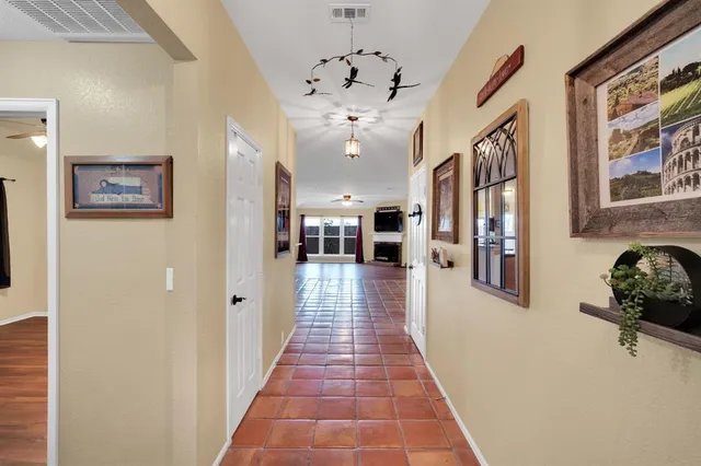 a hallway and a dining room with furniture and a chandelier