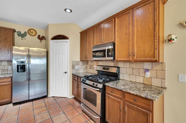 a kitchen with stainless steel appliances granite countertop a sink stove and cabinets