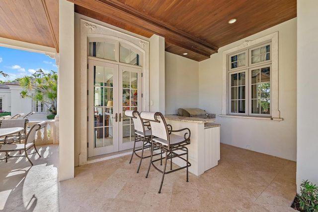 a view of a patio with table and chairs potted plants and palm tree