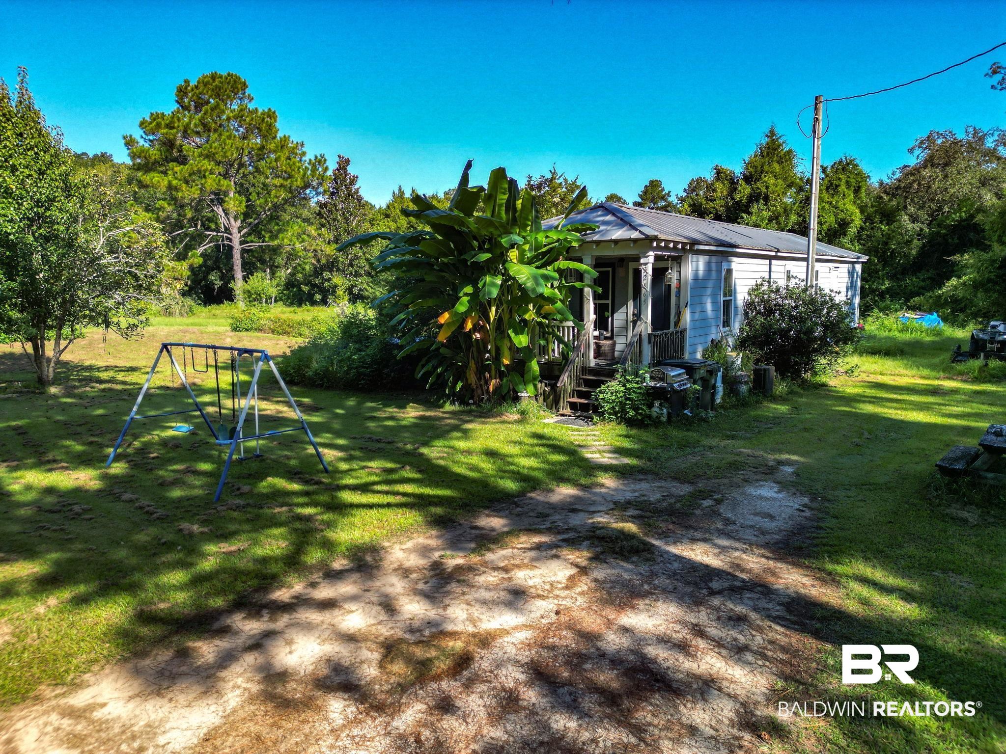 32465 Jay Kee Lane Elberta, AL 36530 - Photo 1 of 17 View of grassy yard featuring a porch and a playground