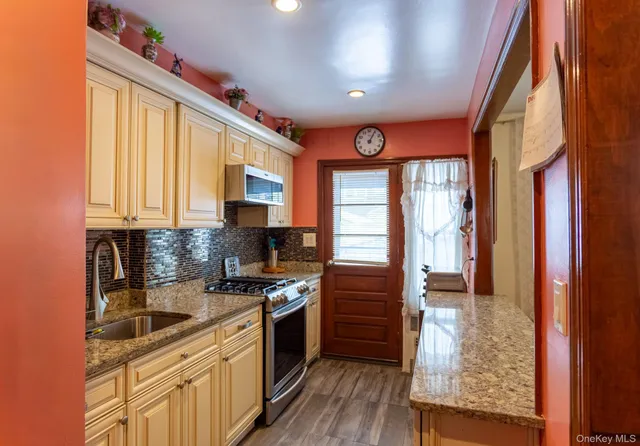 a kitchen with stainless steel appliances granite countertop a stove a sink and a refrigerator