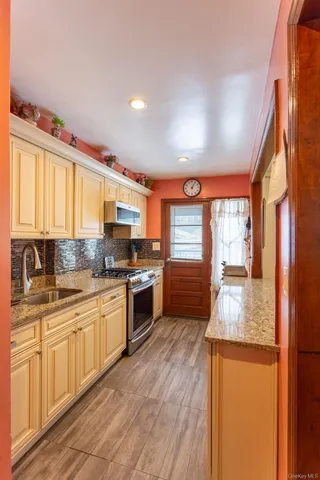 a large kitchen with stainless steel appliances granite countertop a stove a sink and a refrigerator