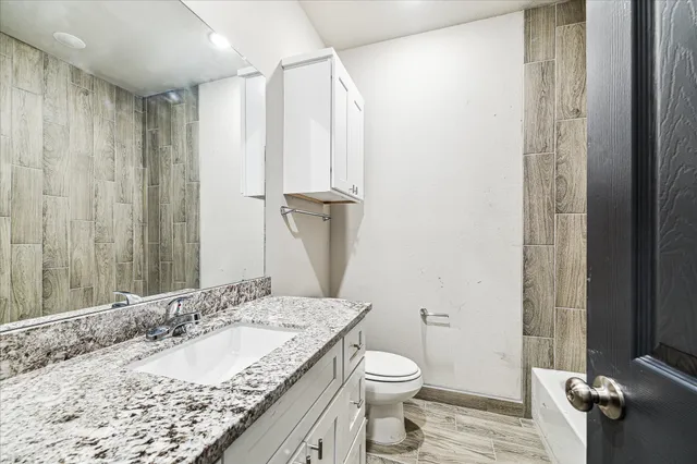 a bathroom with a granite countertop sink and a mirror