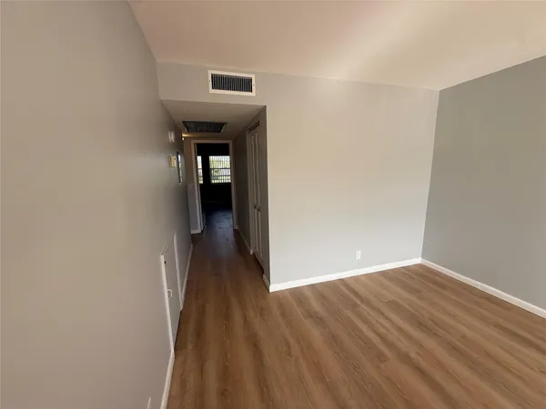an empty room with wooden floor and a window