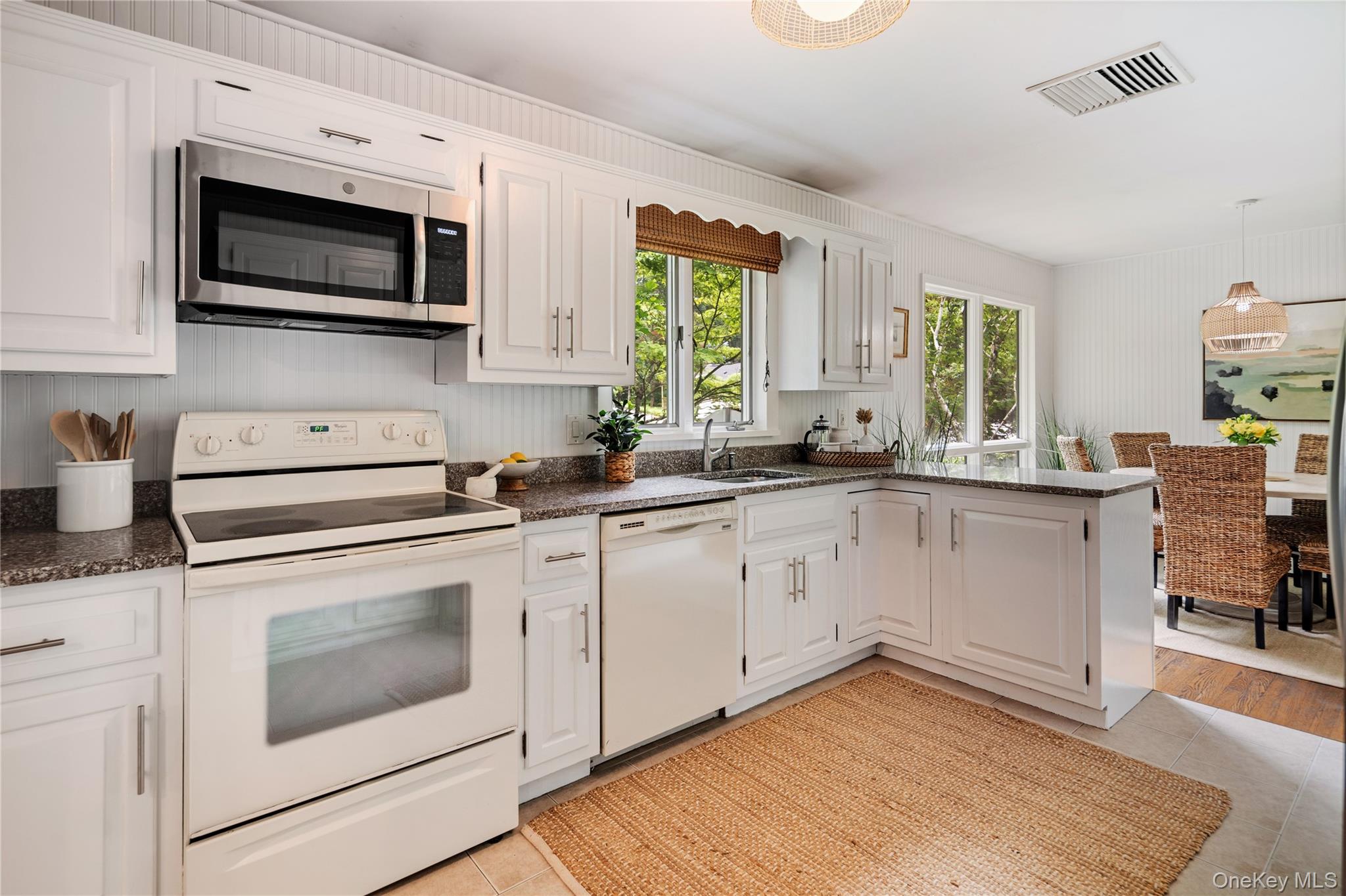 7 Ogden Road Ossining, NY 10562 - Photo 7 of 49 The kitchen boasts plenty of cabinets and counter space, with an oversink window that lets in sunlight and offers lovely garden views. Beadboard walls add to its charming appeal.