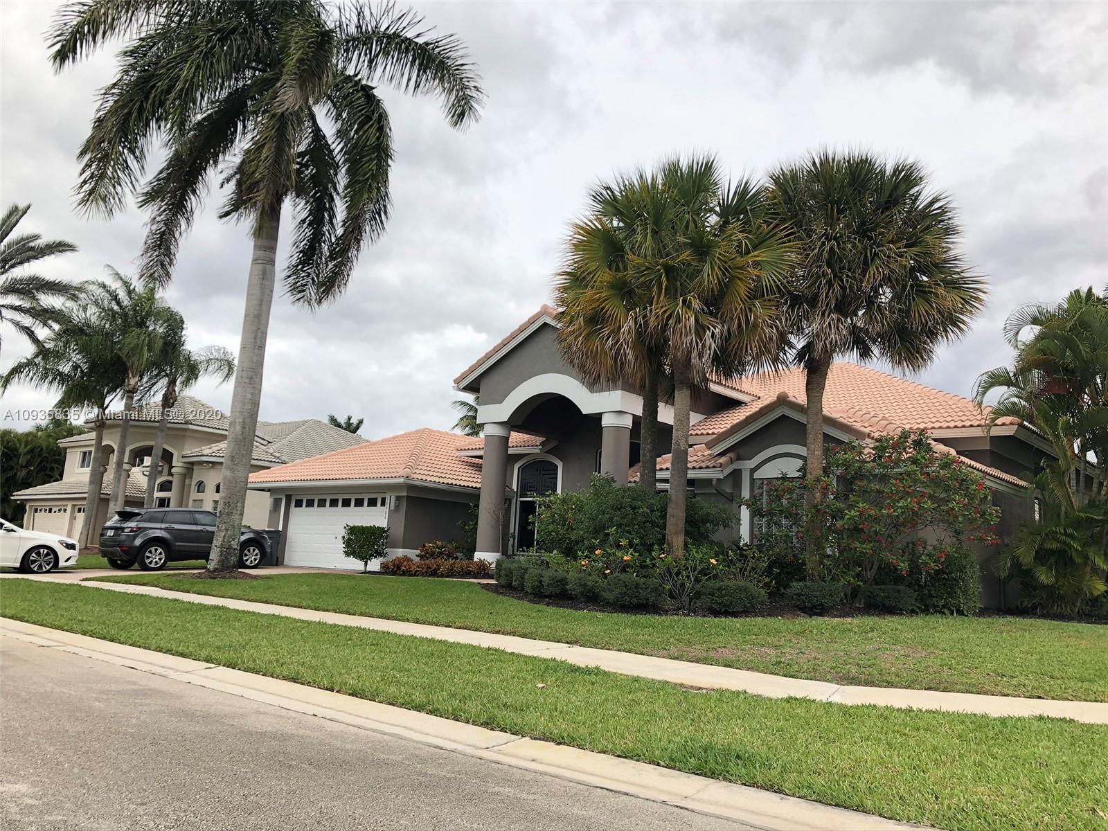 Boca Isles Boca Raton, FL 33498 - Photo 15 of 17 a front view of a house with a garden and trees
