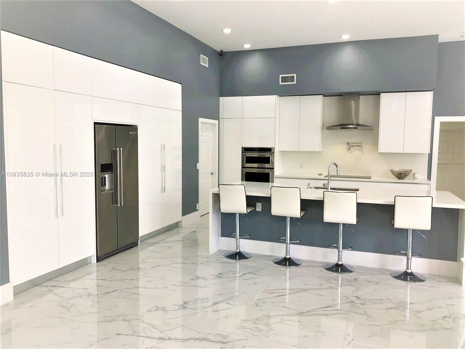 Boca Isles Boca Raton, FL 33498 - Photo 2 of 17 a kitchen with stainless steel appliances kitchen island sink refrigerator and stove