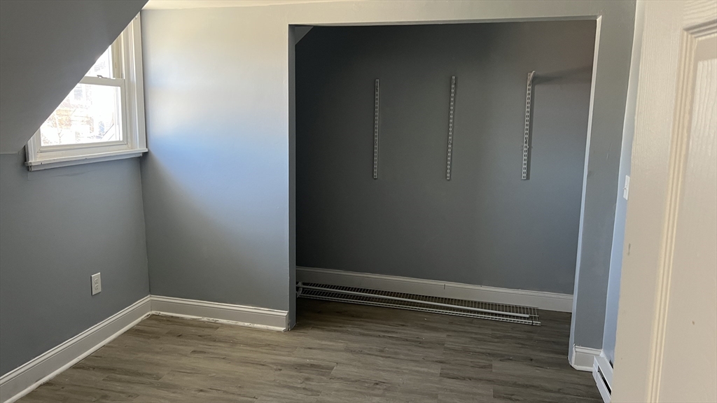 12.5 Benefit Street, Unit 2 Worcester, MA 01610 - Photo 5 of 10 an empty room with wooden floor and closet