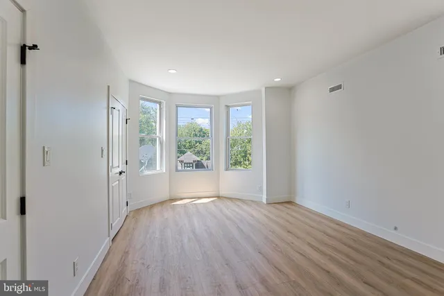 wooden floor in an empty room with a window