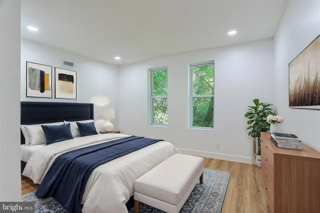 a bedroom with a large bed and a potted plant