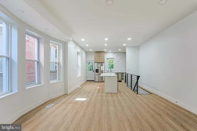 a view of a living room hardwood floor and a kitchen