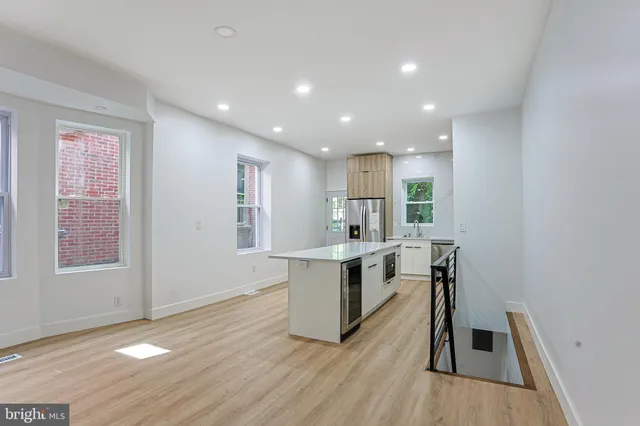 a view of a kitchen with wooden floor and a window