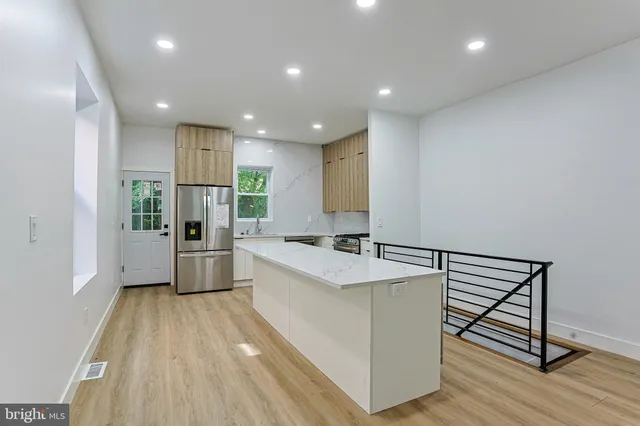 a large white kitchen with a sink a stove and refrigerator