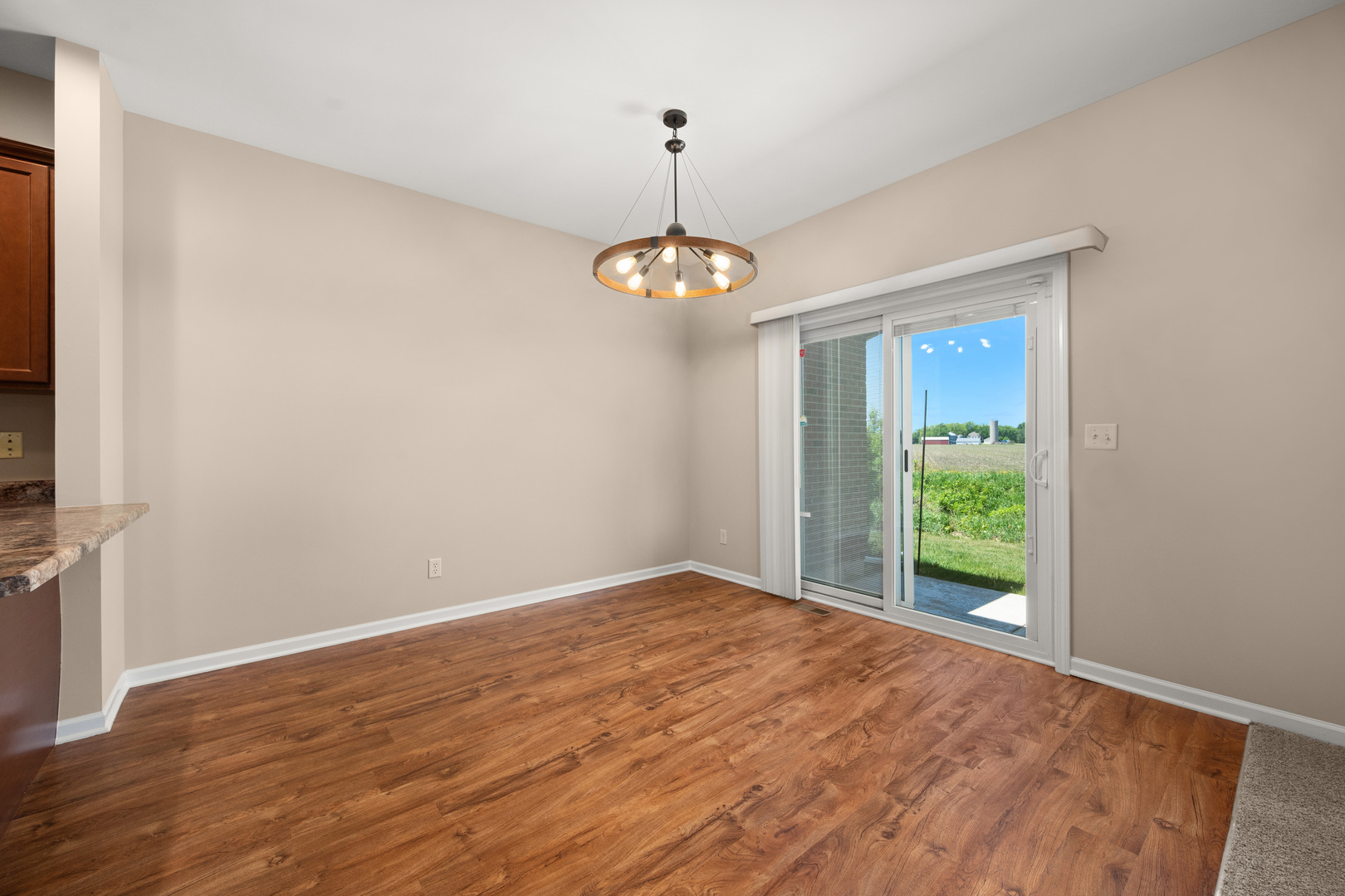 3705 Green Tree Lane DeKalb, IL 60115 - Photo 11 of 31 a view of a room with window wooden floor and a chandelier