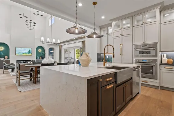 a kitchen with stainless steel appliances a stove center island a dining table and chairs