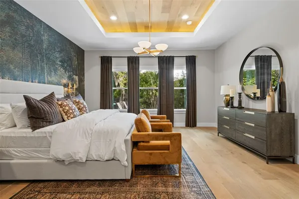 a bedroom with a bed and large windows