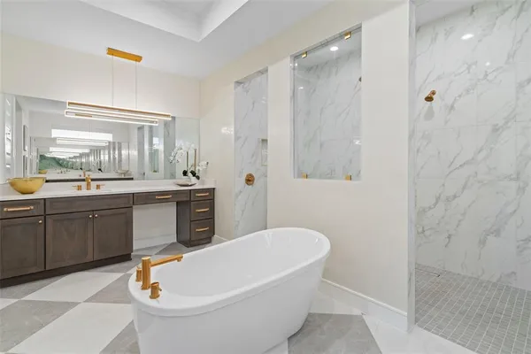 a bathroom with a tub a sink and a large mirror