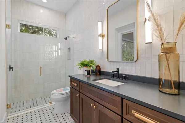 a bathroom with a sink a toilet and mirror