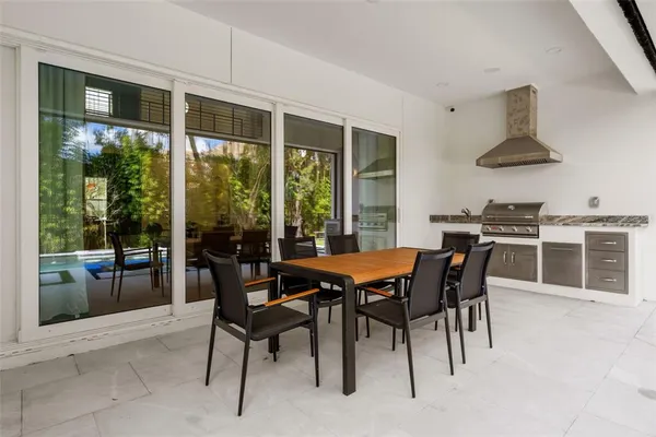 a dining room with furniture and large windows