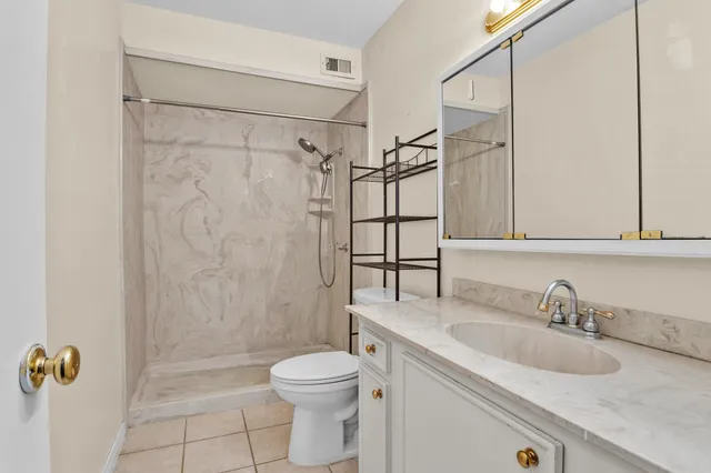a bathroom with a granite countertop sink toilet and shower