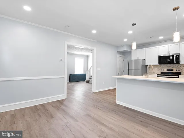 a view of kitchen with wooden floor and electronic appliances