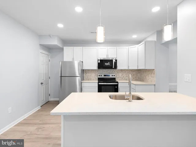 a kitchen with kitchen island a sink stainless steel appliances and cabinets