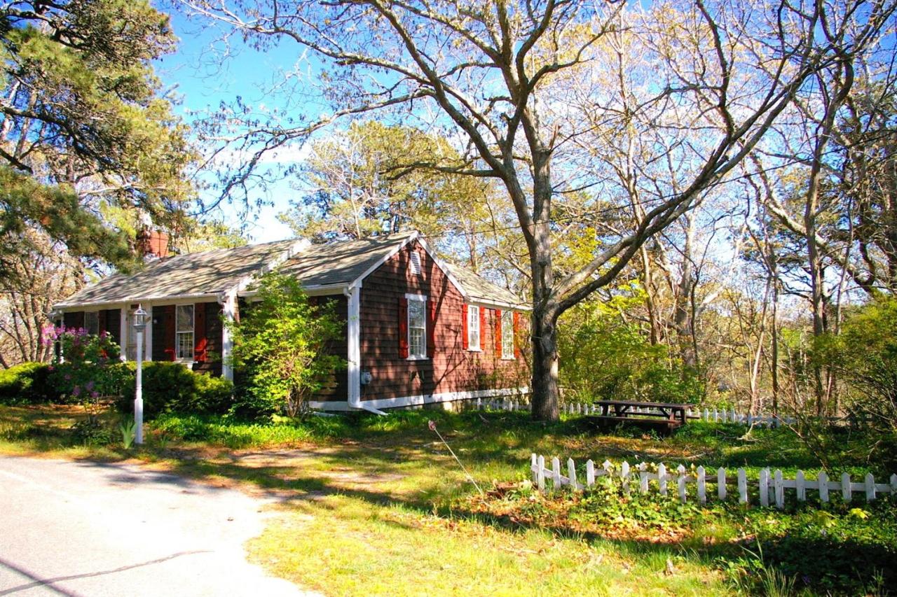 125 Mill Hill Road Wellfleet, MA 02667 - Photo 16 of 22 a front view of a house with a garden and trees