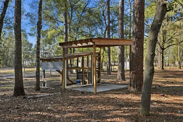 a view of a house with backyard next to a large tree