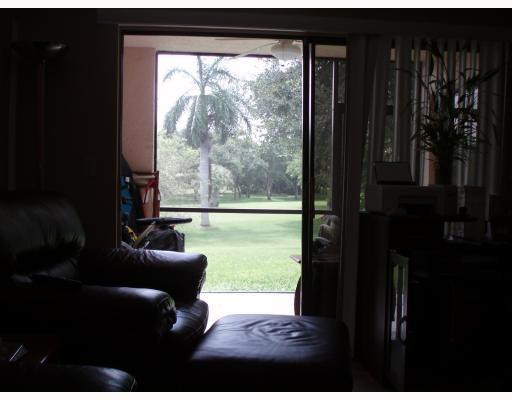 3151 Leewood Terrace, Unit L127 Boca Raton, FL 33431 - Photo 6 of 6 a living room with hardwood floor and a floor to ceiling window