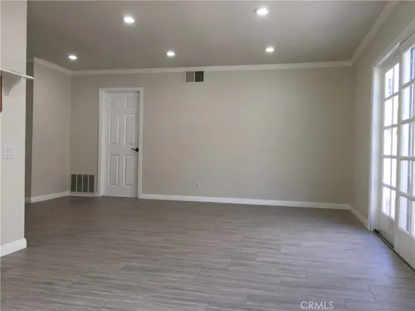 an empty room with floor to ceiling windows and fireplace