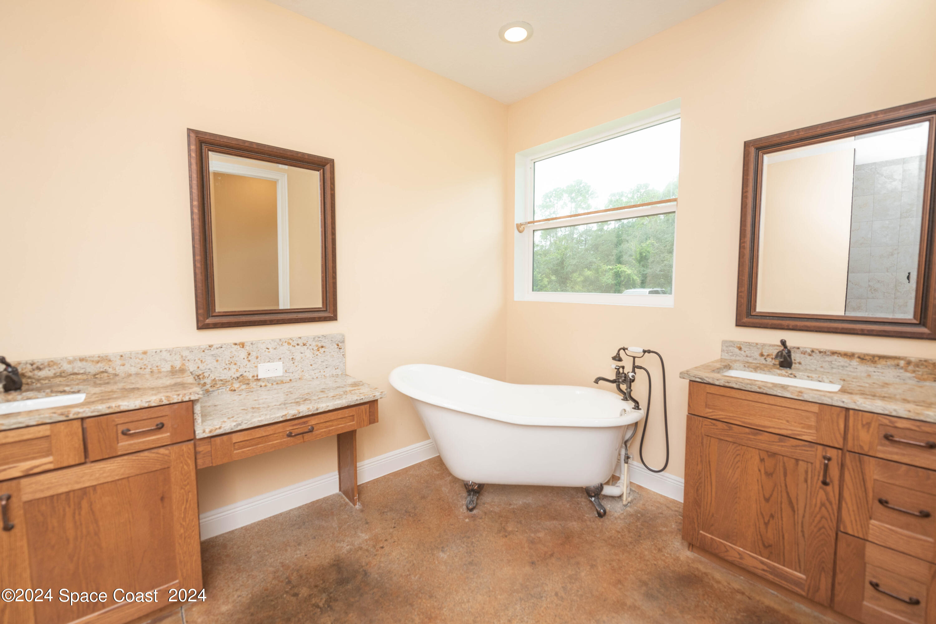 3750 Hield Road Melbourne, FL 32904 - Photo 25 of 63 a bathroom with a granite countertop sink mirror vanity bathtub and next to a window