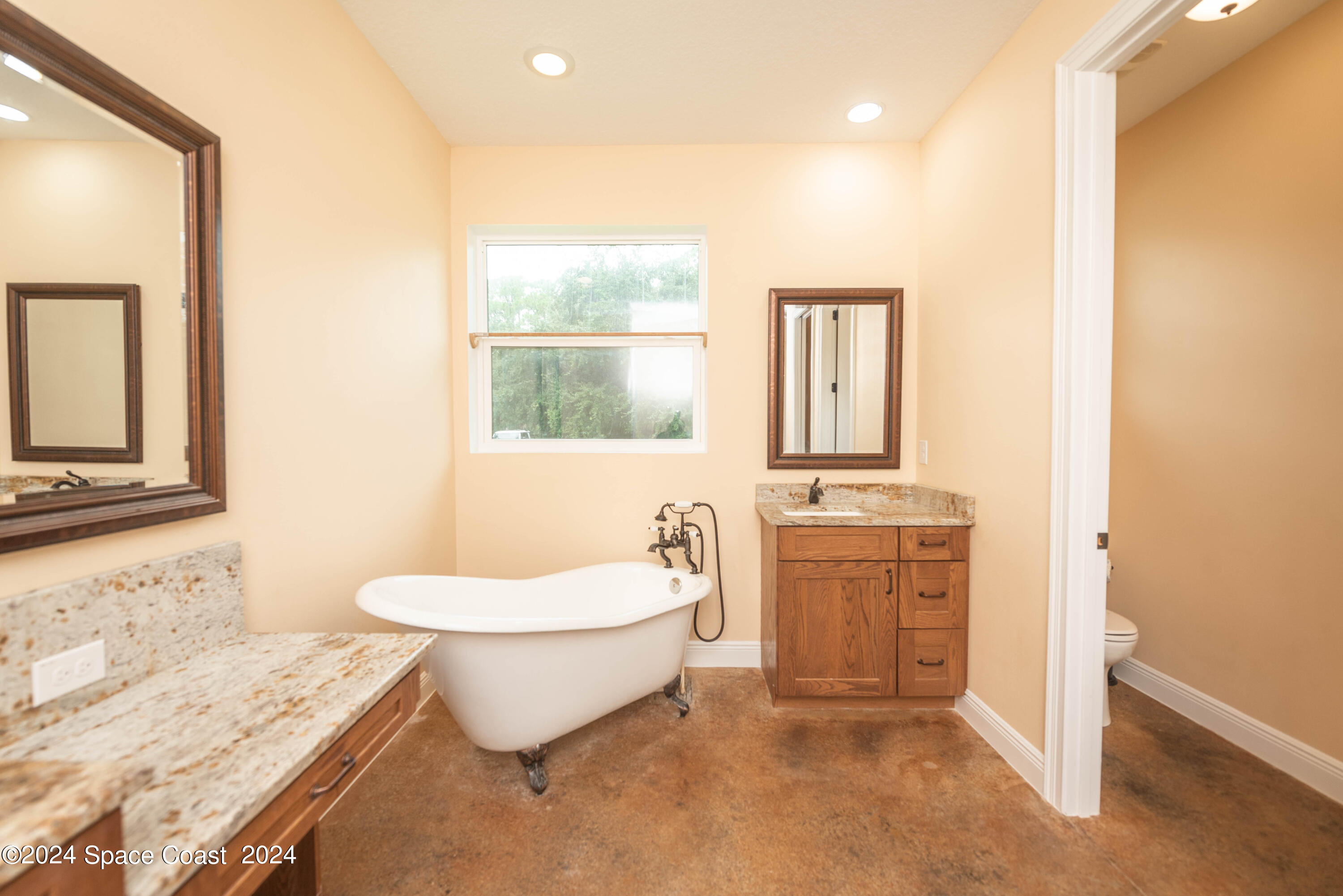 3750 Hield Road Melbourne, FL 32904 - Photo 26 of 63 a bathroom with a granite countertop sink mirror vanity and a toilet