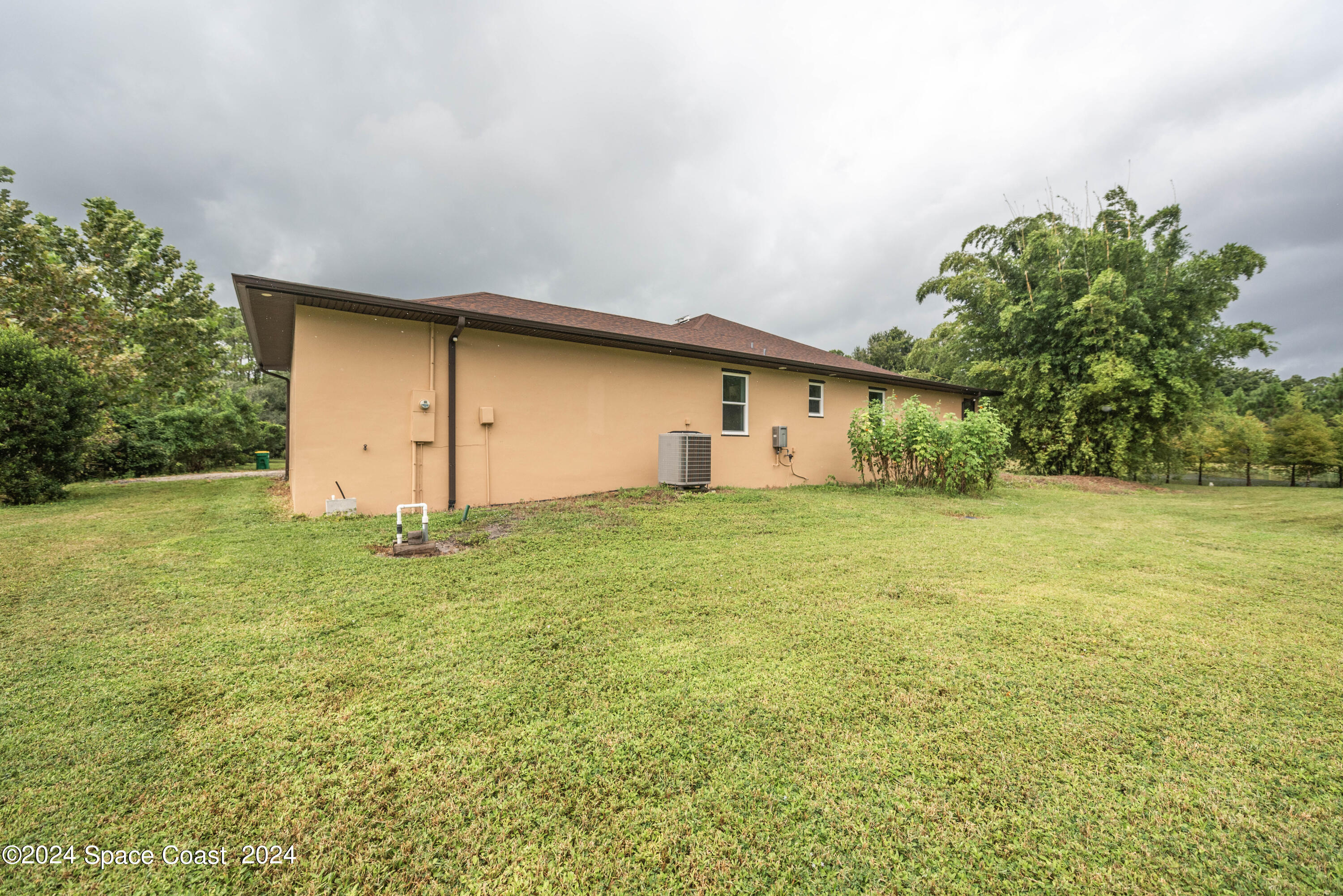 3750 Hield Road Melbourne, FL 32904 - Photo 56 of 63 a backyard of a house with plants and large trees