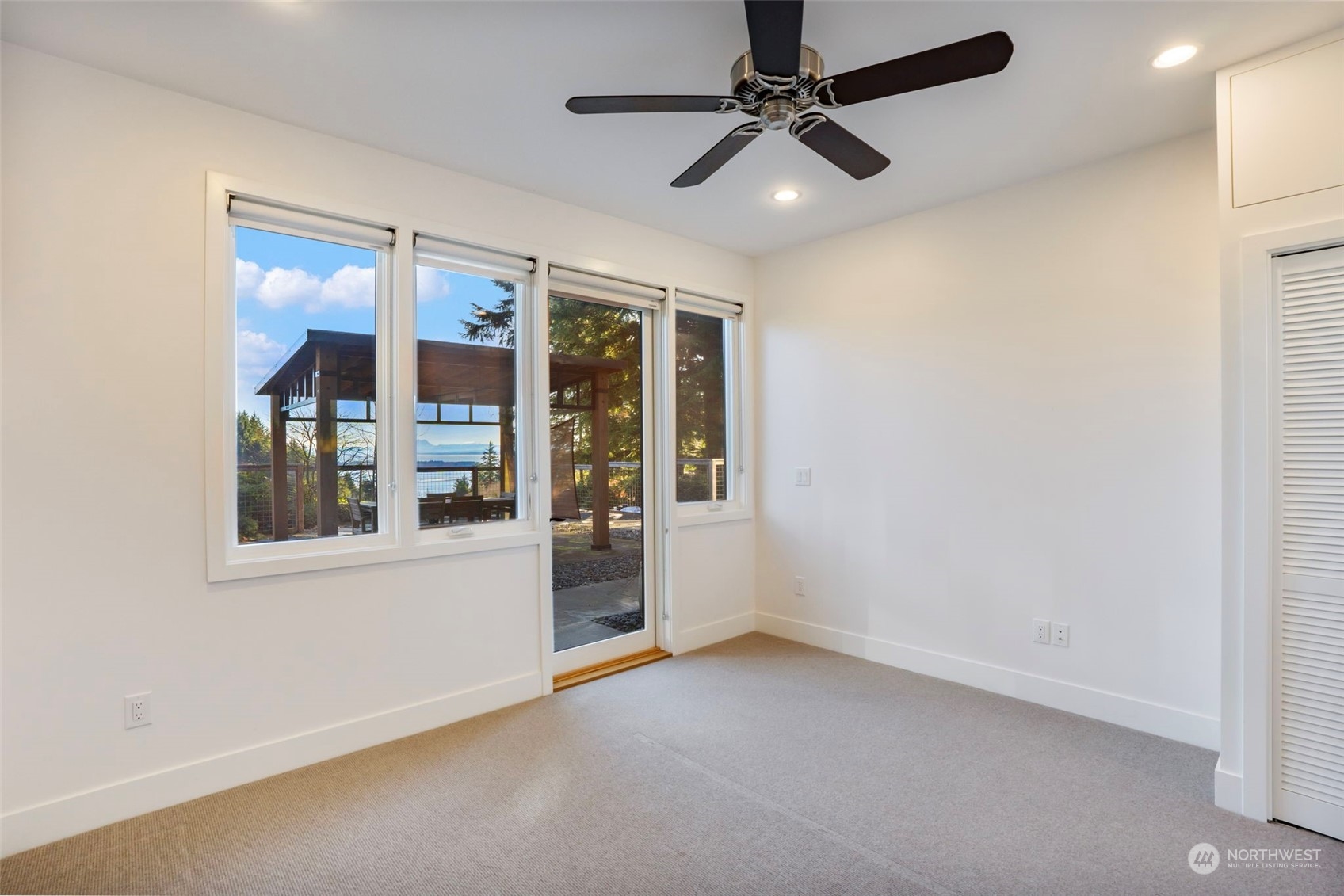 3010 Lighthouse Keepers Road Ilwaco, WA 98624 - Photo 29 of 38 an empty room with chandelier fan and windows