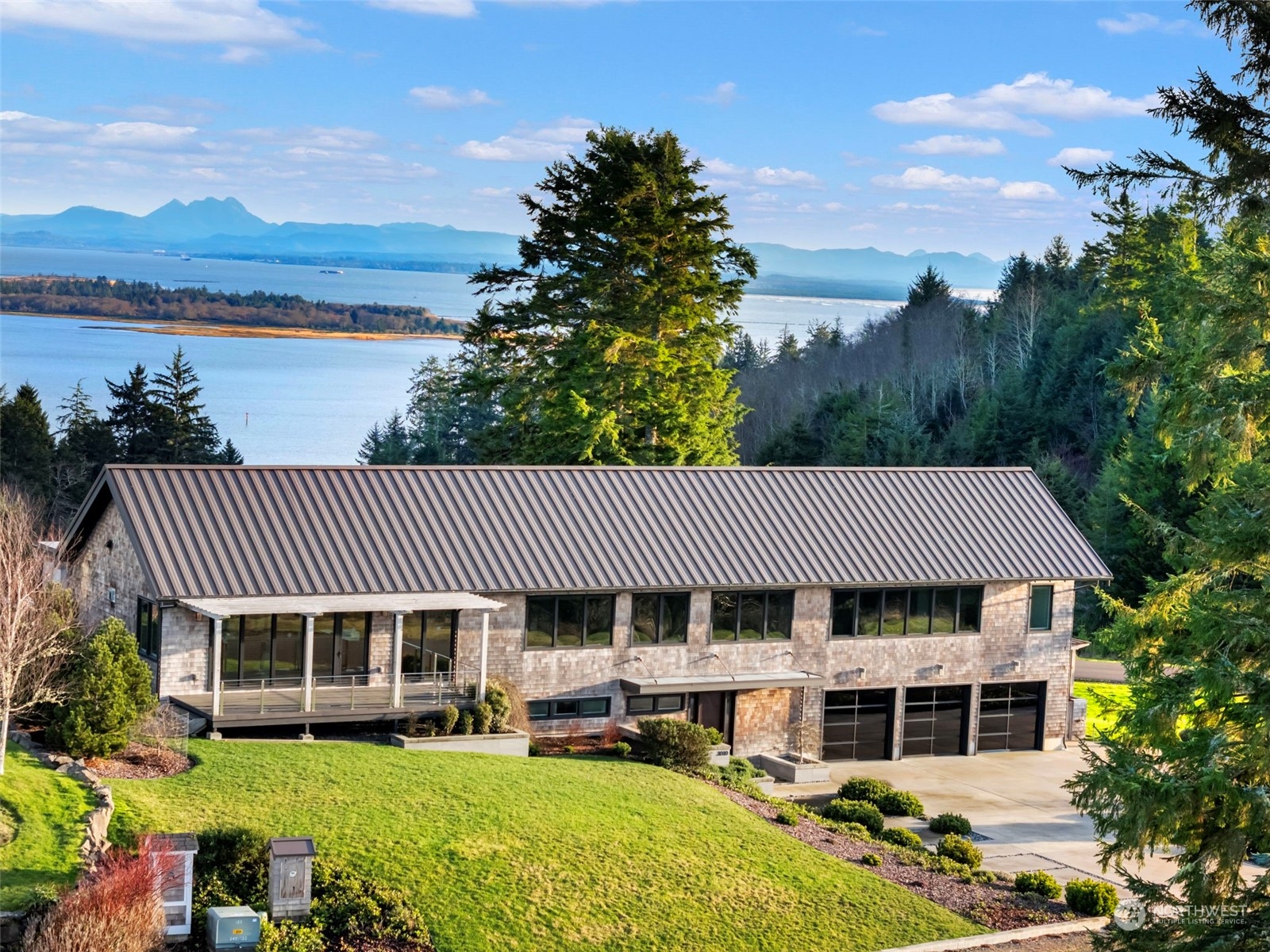 3010 Lighthouse Keepers Road Ilwaco, WA 98624 - Photo 3 of 38 a front view of a house with a garden and lake view