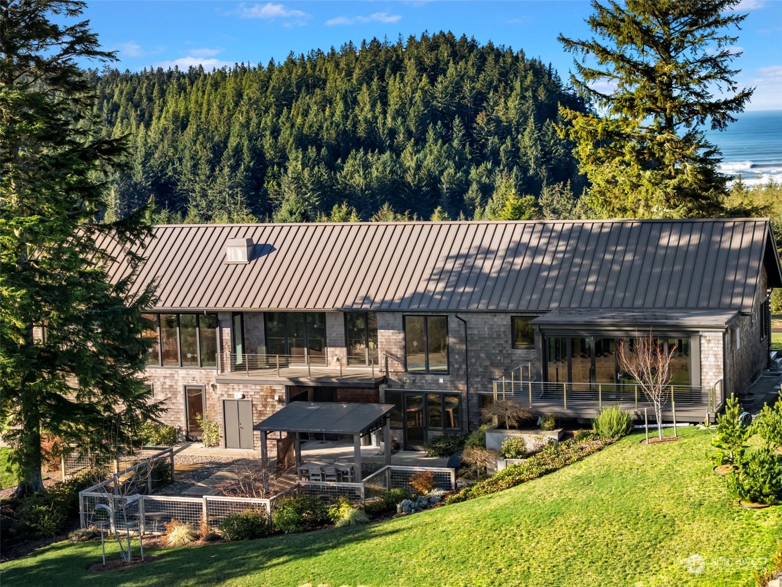 3010 Lighthouse Keepers Road Ilwaco, WA 98624 - Photo 33 of 38 a view of a patio with table and chairs potted plants and large tree