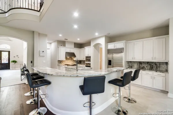 a kitchen with stainless steel appliances kitchen island granite countertop a refrigerator and stove