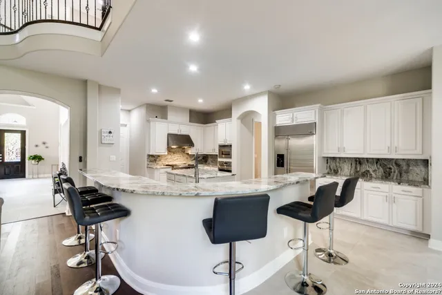 a kitchen with stainless steel appliances kitchen island granite countertop a refrigerator and stove