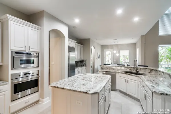 a kitchen with stainless steel appliances granite countertop a stove and a refrigerator