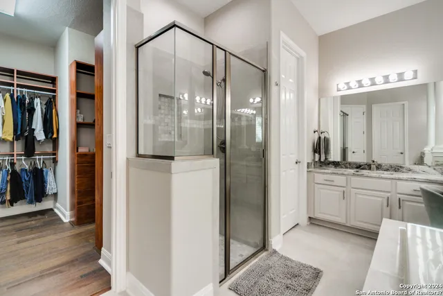 a bathroom with a granite countertop sink mirror and shower