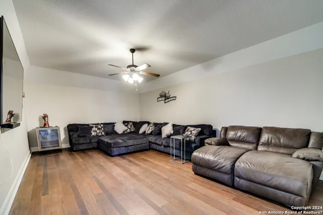 a living room with furniture and a wooden floor
