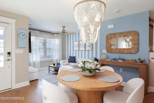 a dining room with furniture a chandelier and wooden floor